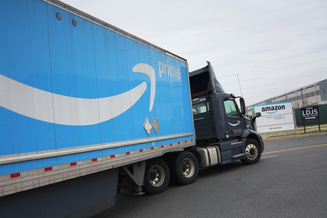 Um caminhão da Amazon entra no estacionamento de um armazém